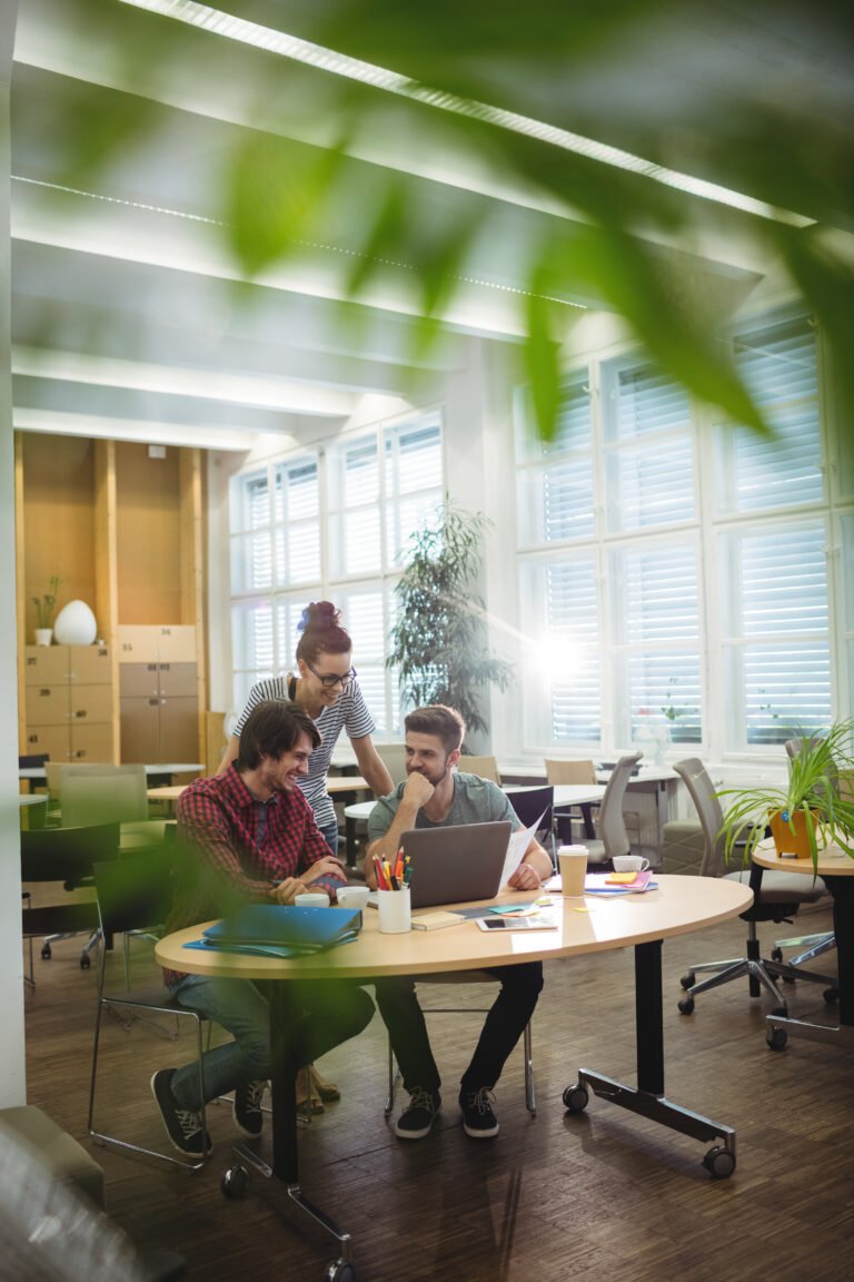 Group of business executives discussing over laptop at their desk in the office